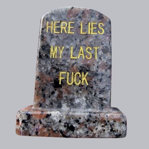 Yooperlit ásvány sírkő Here lies my last fuck felirattal, szürkés mintázatú faragott dísztárgy
